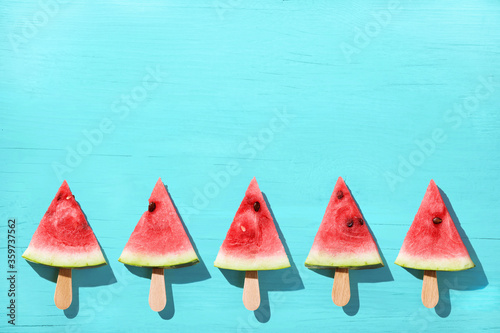 Watermelon slice popsicles on a blue color background