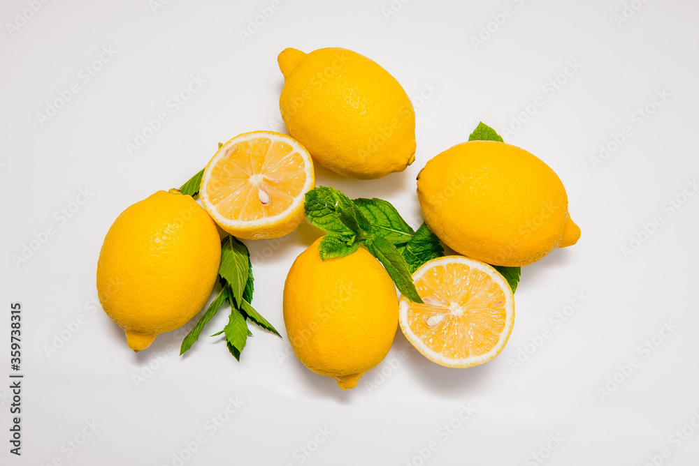 Group of fresh and yellow lemons with a sprig of mint isolated on white background Group of fresh and yellow lemons with a sprig of mint isolated on white background