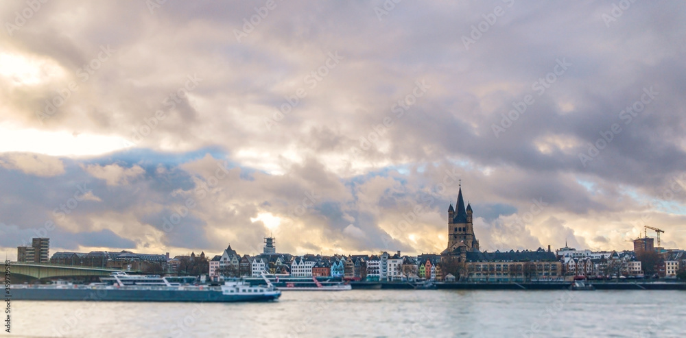Wide color panorama of the city of Cologne, skyscrapers, cathedral, sky clouds, river, cranes,boats.