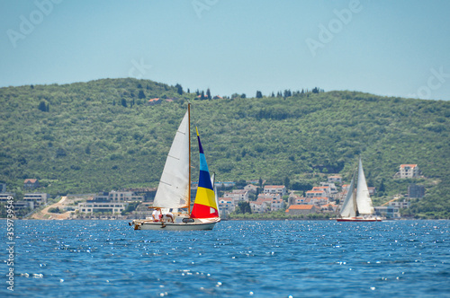 sailing boats in the Adriatic sea on the background of the coast with a village