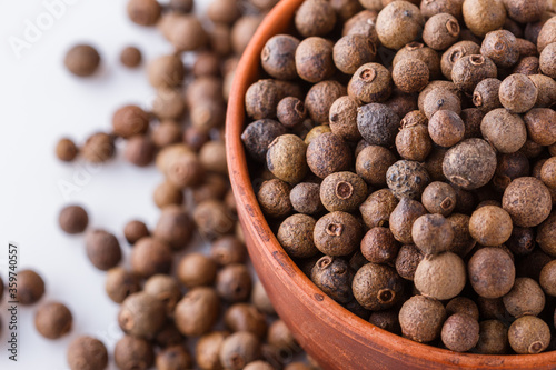 fresh spicy peppers allspice on white acrylic background
