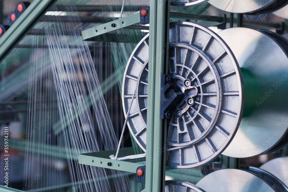 Naklejka premium mechanical equipment at a garment factory. thread manufacturing tools.