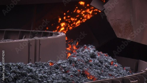 Close up view of the conveyor delivers a hot coal. Mining equipment.