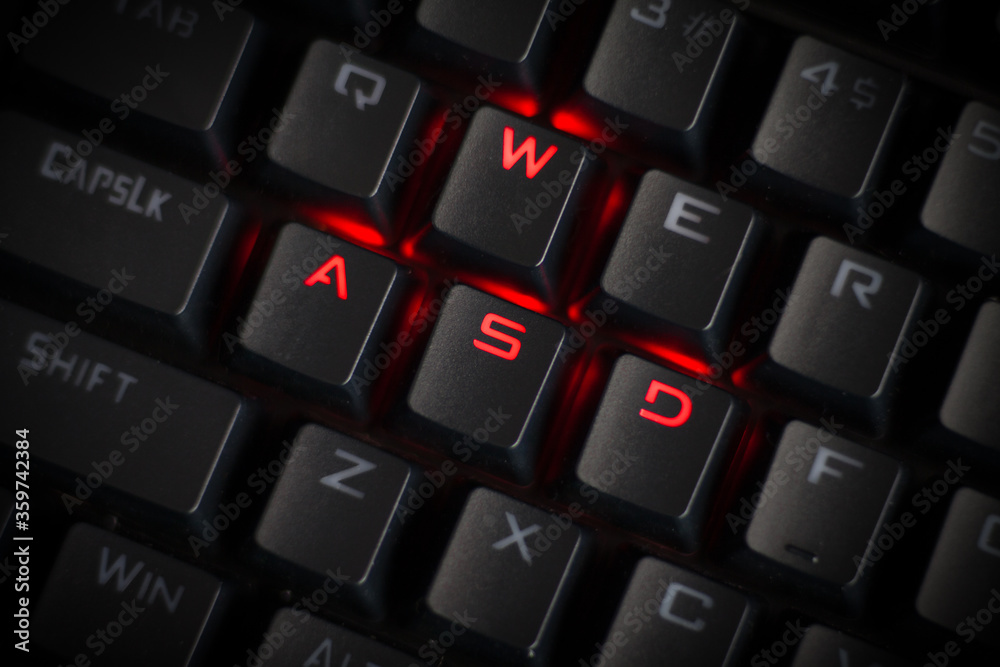 WASD keys light up in red on cool RGB mechanical gaming keyboard. WASD keys  are used in many video games. Stock Photo | Adobe Stock