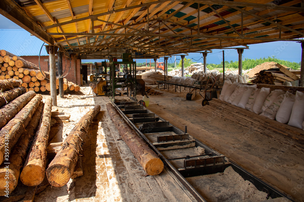 Sawmill under the roof under the open sky . Equipment for processing logs.