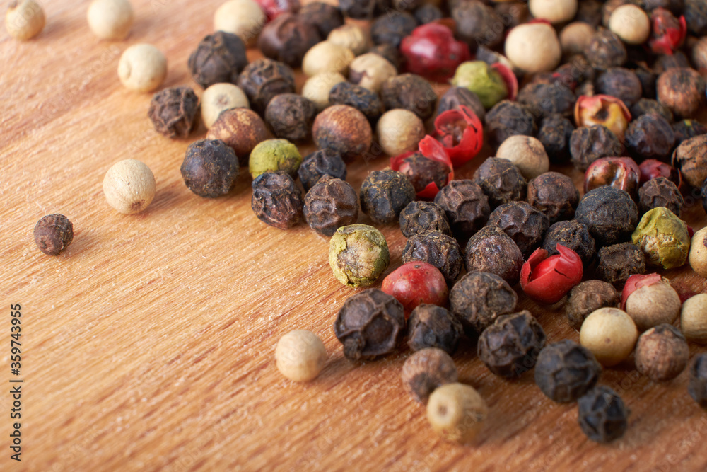 A mixture of peppers. Black, white, red polka dots. Isolated on a wooden background. The selected sharpness A mixture of peppers. Black, white, red polka dots. Isolated on a wooden background. The selected sharpness