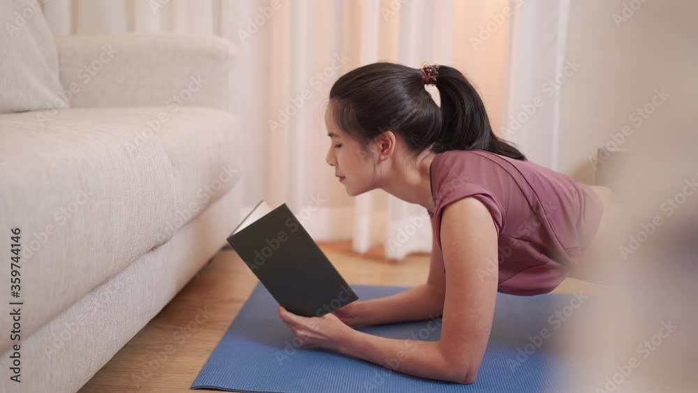 Asian Young woman planking and reading at the same time, exercise during covid-19 lock down, home work out exercising in living room with sofa, home education college student review study note lecture Asian Young woman planking and reading at the same time, exercise during covid-19 lock down, home work out exercising in living room with sofa, home education college student review study note lecture