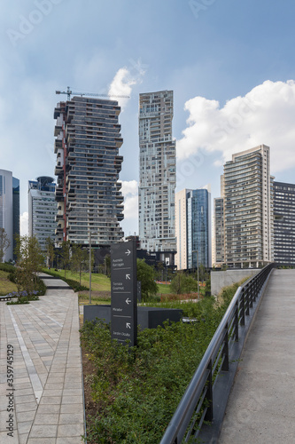 central walking path of La Mexicana urban park in Santa Fe, Mexico City with tall buildings in the back photo