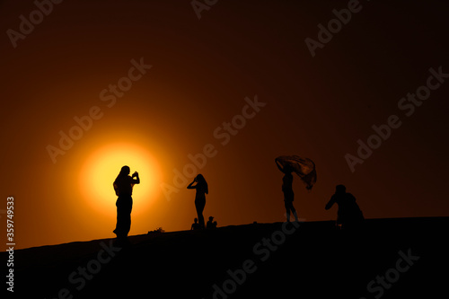 group of people walking on the desert of Dubai at sunset