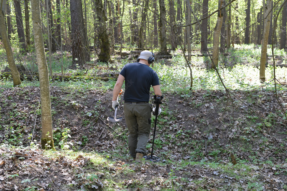 Digger with a metal detector in the thicket Digger with a metal detector in the thicket