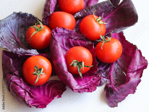 ripe tomatoes and red cabbage leaves close up