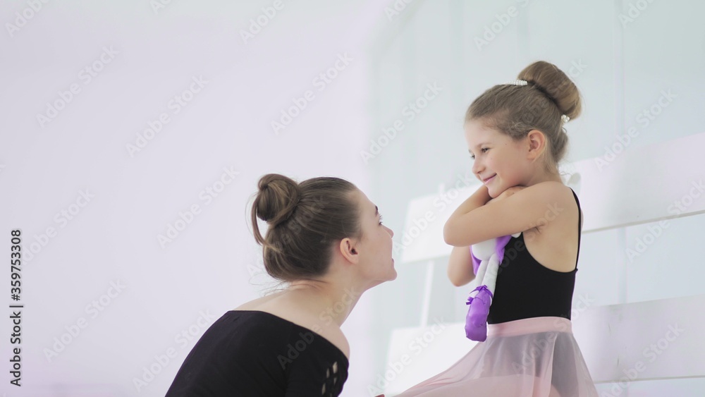 Cute Female ballet teacher gives his sad student a toy Cute Female ballet teacher gives his sad student a toy