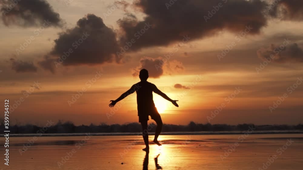 Silhouette of Man Yoga Pose on The Beach During Sunset in Slow Motion Silhouette of Man Yoga Pose on The Beach During Sunset in Slow Motion