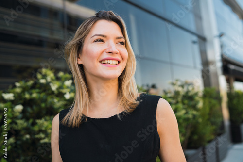 Business woman standing outside office buildings.