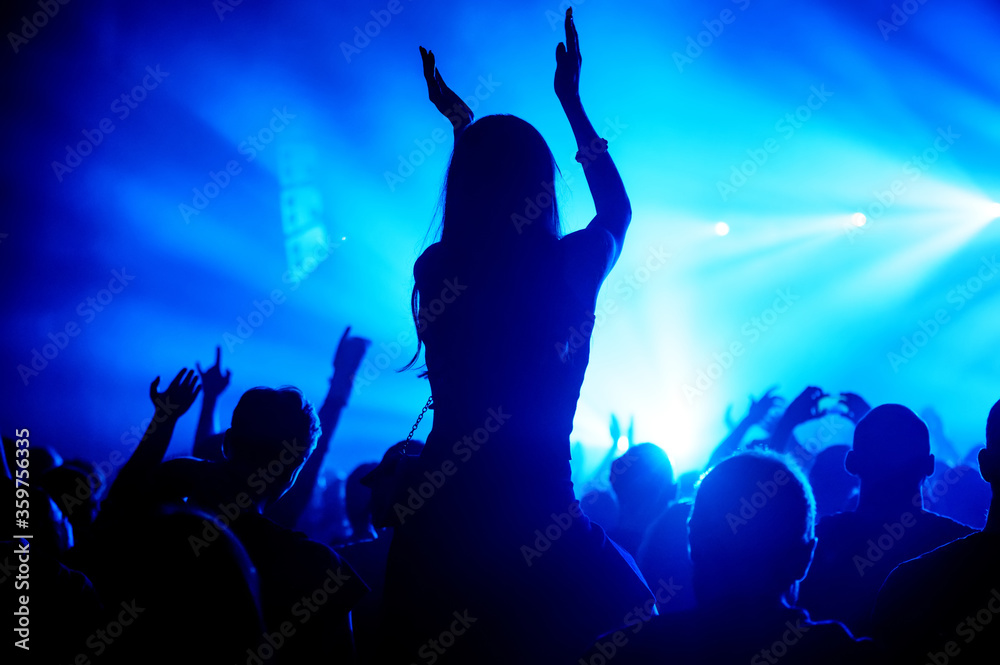 silhouette of a happy applauding girl in a crowd at a concert. atmosphere of a music festival. summer show banner