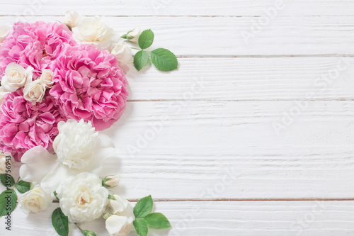 pink and white roses on white wooden background © Maya Kruchancova