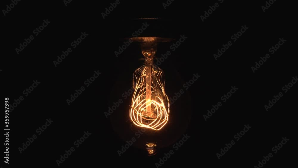 Tungsten light bulb lamp cozy dimming over black background, macro close up shot of old retro vintage light bulb turn off light. Comfort cozy concept. 4k.