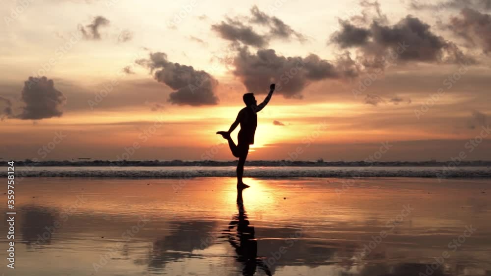 Silhouette of Man Yoga Pose on The Beach During Sunset in Slow Motion Silhouette of Man Yoga Pose on The Beach During Sunset in Slow Motion