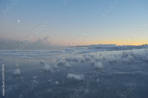 ice fog over frozen fjord with pink sunset sky