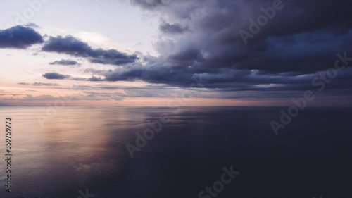 Aerial photo from flying drone of a beautiful nature landscape with amazing dramatic sky and sunrise over Indian Ocean in evening time. Wonderful view with colorful clouds  sunrise and seascape