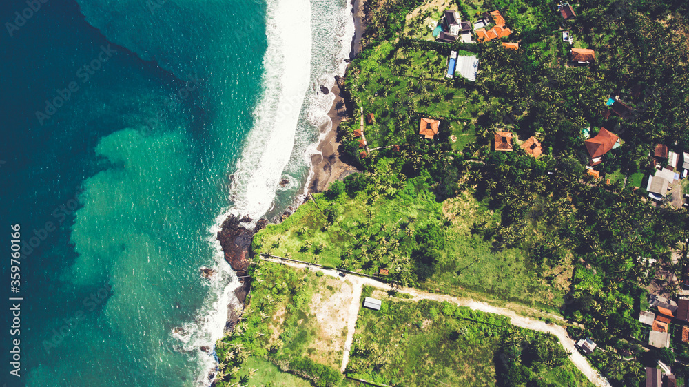 Aerial top view photo from drone of a paradise beach with tropical plants and blue calm sea. Beautiful nature wallpaper. Amazing view on a Asian island with luxury hotels and rental villas near ocean
