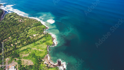 Aerial top view photo from drone of a paradise beach with tropical plants and blue calm sea. Beautiful nature wallpaper. Amazing view on a Asian island with luxury hotels and rental villas near ocean
