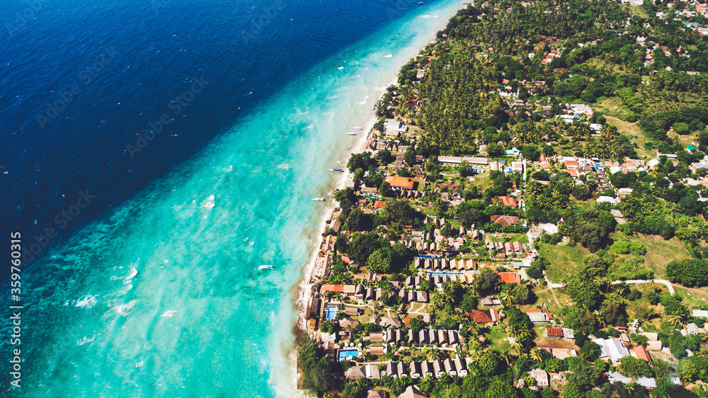 Aerial photo from drone of perfect sand and crystal clear water in a thousand shades of blue all this in Paradise island of Indonesian archipelago. Luxury villas, beautiful hotels, and famous Resorts