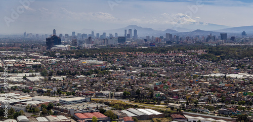 aerial view of Mexico Cities skyline with a living district in front, commercial, financial y business areas in the middle, and two volcanoes in the back photo