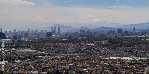 aerial view of Mexico Cities skyline with a living district in front, commercial, financial y business areas in the middle, and two volcanoes in the back