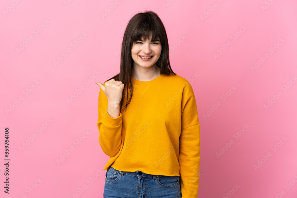 Young Ukrainian woman isolated on pink background pointing to the side to present a product Young Ukrainian woman isolated on pink background pointing to the side to present a product