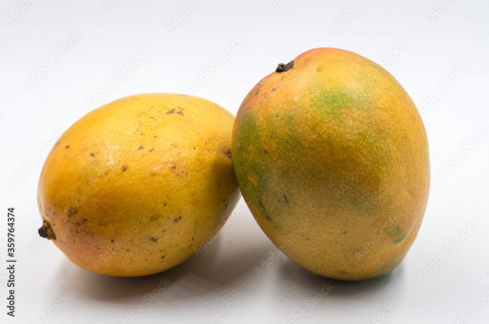 Two yellow and ripe mangoes isolated on white background Two yellow and ripe mangoes isolated on white background