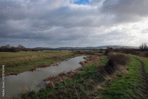 Countryside landscape of River Ader and meadow near Shoreham-by-Sea, England