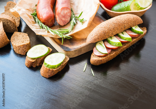 Sandwich. Rye Baguette with Sausage and cucumbers.