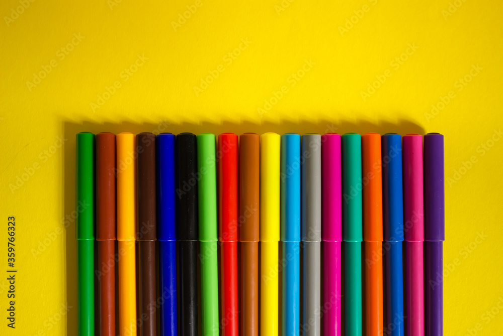 set of multi-colored felt-tip pens pencils on a yellow background set of multi-colored felt-tip pens pencils on a yellow background
