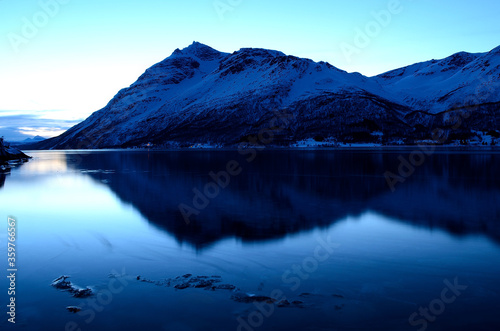 blue frozen fjord and snowy mountain during the blue hour in northern norway © Arcticphotoworks