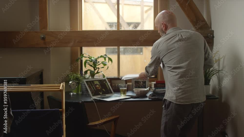 Busy stressed man has a video chat work meeting while folding clothes while quarantined at home Busy stressed man has a video chat work meeting while folding clothes while quarantined at home