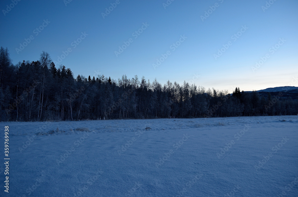 cold frozen field, beautiful sky and mountains in the arctic circle cold frozen field, beautiful sky and mountains in the arctic circle