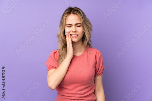 Teenager Russian girl isolated on purple background with toothache