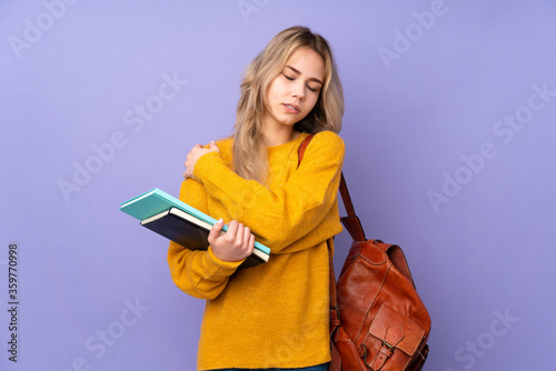 Teenager Russian student girl isolated on purple background suffering from pain in shoulder for having made an effort