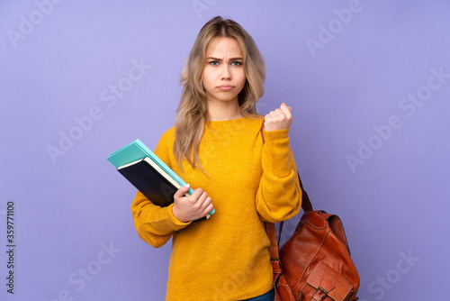 Teenager Russian student girl isolated on purple background with angry gesture