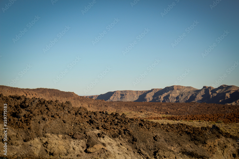 A dry mountain range in Tenerife, spain against a clear blue sky