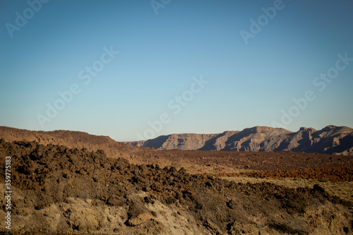 A dry mountain range in Tenerife, spain against a clear blue sky