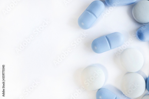 white and blue pills. Healthcare View from above. WITH PLACE for text from the left.WHITE BACKGROUND