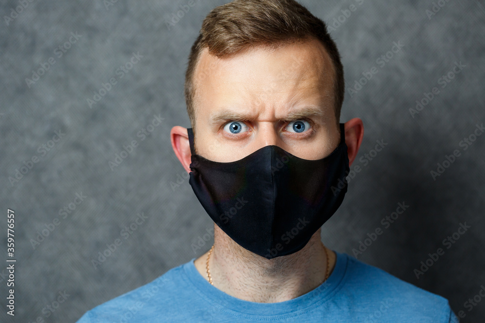 young guy man in black protective medical mask against viruses. COVID 19 young guy man in black protective medical mask against viruses. COVID 19