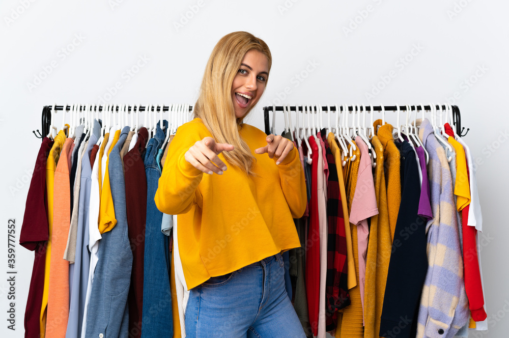 Young Uruguayan blonde woman in a clothing store pointing to the front and smiling Young Uruguayan blonde woman in a clothing store pointing to the front and smiling