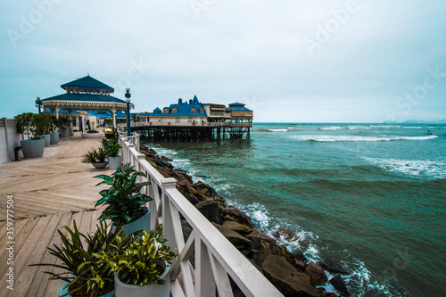White and blue wood pier and restaurant by the beach in Lima Peru