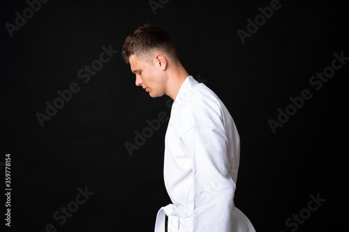 Young man doing karate over isolated black background