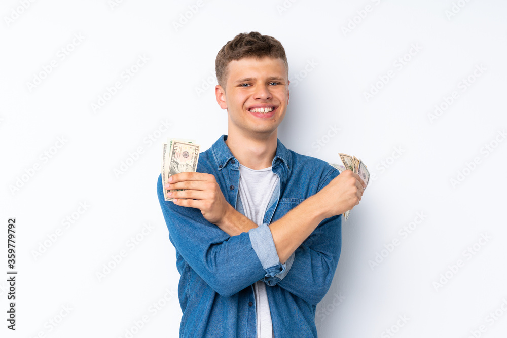 Young handsome man over isolated white background taking a lot of money Young handsome man over isolated white background taking a lot of money