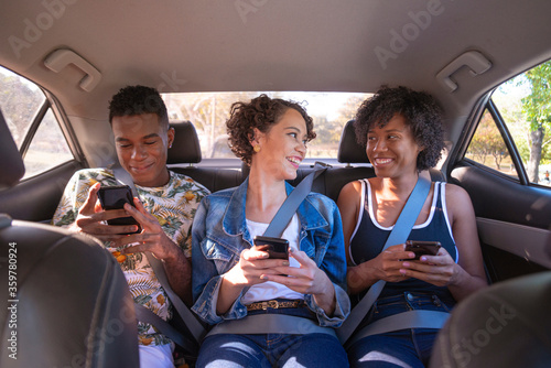 Young people using cellphone during car trip.
