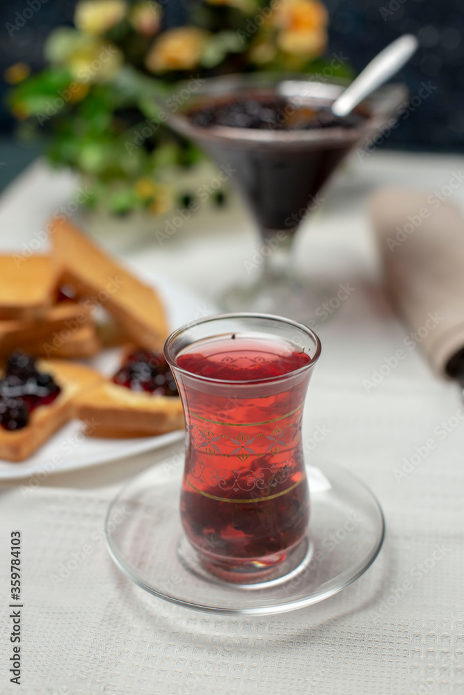 Toast slices with red jam and a glass of tea Toast slices with red jam and a glass of tea